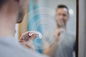 Man preparing silicon tray for teeth whitening