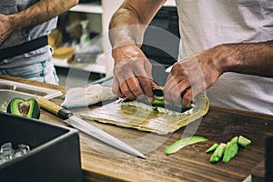 Man preparing sushi meal with avocado at open food market in Ljubljana, Slovenia