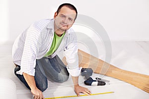 Man preparing to lay some laminate floor planks