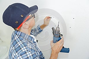 man preparing wall to drill