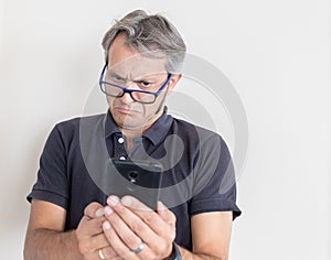 Man with presbyopia looking the smart phone photo