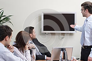 Man presenting data on screen to group