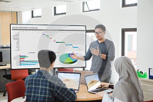 Man presenting to colleagues at a meeting about project management.