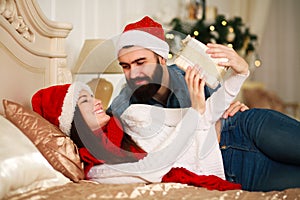 Man presents girl New Year's gift, Christmas couple in bed