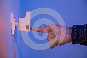 Man press with his finger on WPS button on WiFi repeater which i photo