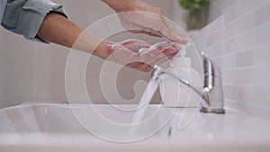 Man press soap bottle and soap bubbles on his hand in preparation for cleaning hands. Men are washing by soap their hands to kill