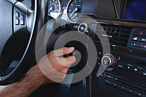 a man presses the start button in the car