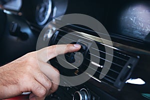 a man presses the start button in the car