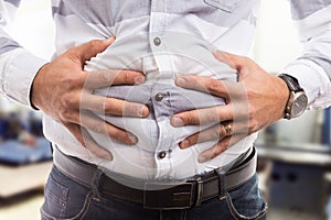 Man pressing bloated abdomen or belly as cramp flatulence problem.