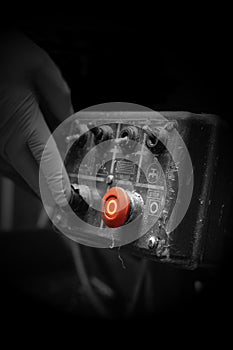 Man pressing button on an industrial machine control panel. With lighting effect