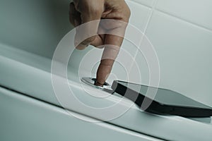man pressing the button to flush the toilet
