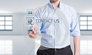 Man pressing contact us button on transparent touch screen