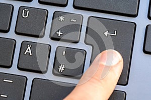 Man pressing the enter key on a black laptop keyboard, finger closeup, completion, sending a message when chatting, confirming a