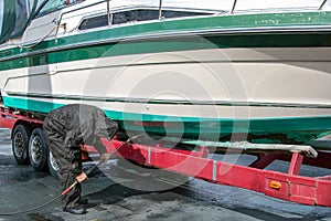 Man pressure washing boat hull