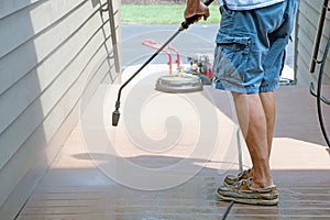 Man pressure washing wooden deck