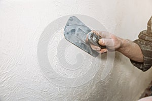 Man is priming a surface with a sandpaper. Grind of wall. Maintenance repair works renovation in the flat. Restoration indoors.