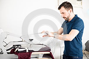 Man printing shirt in a workshop