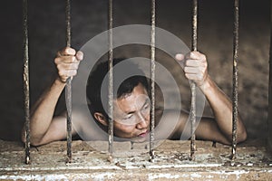 Man in prison hands of behind hold Steel cage jail bars, Male p