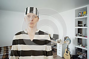 Man in Prisoner Uniform at Home. Lockdown Concept