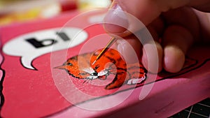 Man in the process of drawing with acrylic paints picture with cat