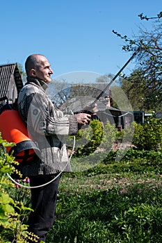 a man processes and sprays an apple tree.