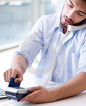 Man processing credit card transaction with POS terminal