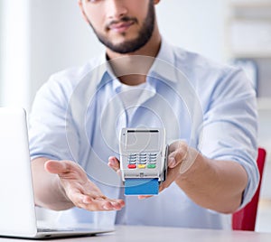 Man processing credit card transaction with POS terminal