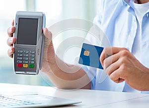 Man processing credit card transaction with POS terminal