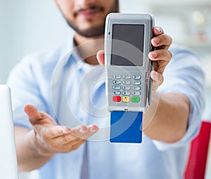 Man processing credit card transaction with POS terminal