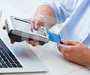 Man processing credit card transaction with POS terminal