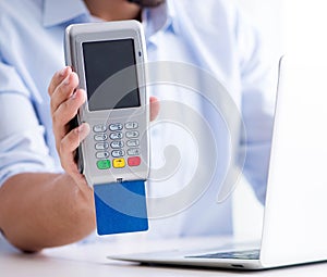 Man processing credit card transaction with POS terminal