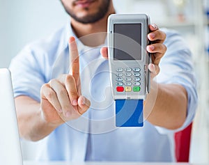 Man processing credit card transaction with POS terminal