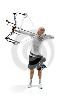 Man, professional archer training, aiming archery bow into target isolated over white studio background. Archery sport