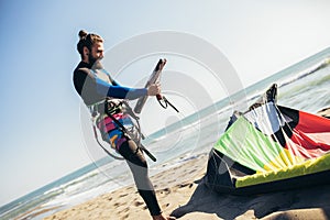 Man professional surfer standing on the sandy beach with his kite