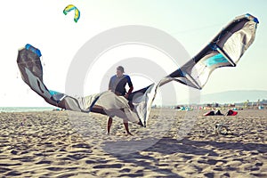 Man professional surfer standing in wetsuit with his kite