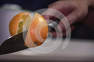 A man professionally cuts a orange