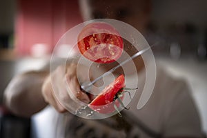 A man professionally cuts a tomato photo