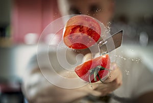 A man professionally cuts a tomato