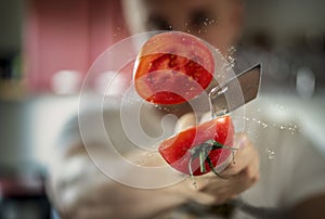 A man professionally cuts a tomato photo