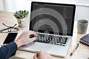 Man programming on a computer, office background