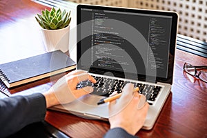 Man programming on a computer, office background