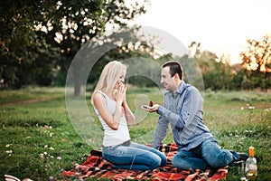 Man proposes to a girl in a park at a picnic
