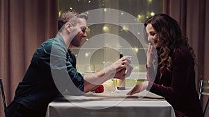 A man proposes to his woman during dinner and she says yes. Romantic dinner.