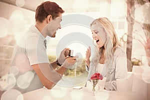 Man proposing marriage to his shocked blonde girlfriend