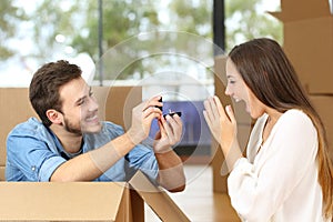 Man proposing to girl with wedding ring moving home photo