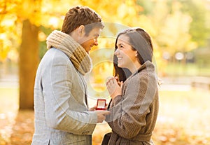 Man proposing to a woman in the autumn park