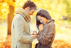 Man proposing to a woman in the autumn park