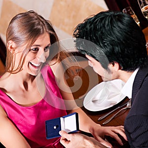 Man proposing to woman in restaurant