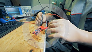 Man with prosthetic hands is soldering a microscheme
