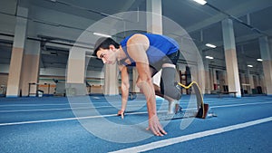 A man with a prosthetic leg start running in the gym